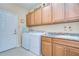 Functional laundry room with cabinets, granite countertops, and modern washer and dryer at 2403 Richmond Greens Ct, Sun City Center, FL 33573