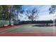 Well-maintained tennis court with benches and mature trees, perfect for outdoor recreation at 2403 Richmond Greens Ct, Sun City Center, FL 33573