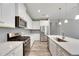 Modern kitchen with white cabinets, quartz countertops, and stainless steel appliances at 5607 Limelight Dr, Apollo Beach, FL 33572