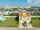 Wide aerial view of the property in a community, featuring a Mediterranean-style home with a red tile roof and lush landscaping at 136 175Th E Ave, Redington Shores, FL 33708