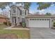 Two-story house with gray siding, white garage door, and landscaping at 10142 Kingsbridge Ave, Tampa, FL 33626