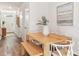 Dining area with wood table, bench seating, and modern art, adjacent to a hallway and kitchen at 17769 Crescent Moon Loop, Lakewood Ranch, FL 34211