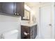 Clean bathroom with dark brown vanity, marble countertop, and a toilet at 2367 Woodlawn W Cir, St Petersburg, FL 33704