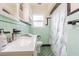 Retro bathroom with mint green tile, shower/tub combo, and a vanity at 2367 Woodlawn W Cir, St Petersburg, FL 33704