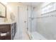 Modern bathroom with walk-in shower, dark brown vanity, and marble countertop at 2367 Woodlawn W Cir, St Petersburg, FL 33704