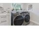 Bright laundry room features modern Samsung washer and dryer, stylish tile, and ample counter space at 2367 Woodlawn W Cir, St Petersburg, FL 33704