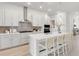 Modern kitchen with white cabinets, hexagon backsplash, and island with seating at 6258 Broad Field Ave, Apollo Beach, FL 33572