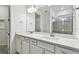 Double vanity bathroom with white cabinets, quartz countertops, and a large mirror at 9415 Coastline Way, Parrish, FL 34219