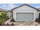 House exterior features a gray garage door, light-colored brick driveway, and walkway at 9415 Coastline Way, Parrish, FL 34219