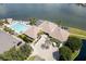 Aerial view of the clubhouse, pool, hot tub, parking lot and circular drive near the waterway at 9495 Blind Pass Rd # 206, St Pete Beach, FL 33706