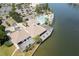 An aerial view of a clubhouse with a pool, waterfront deck, and parking lot on a sunny day at 9495 Blind Pass Rd # 206, St Pete Beach, FL 33706