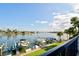 View of boat docks from a private balcony with grassy lawn and blue skies above at 9495 Blind Pass Rd # 206, St Pete Beach, FL 33706