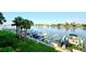 Condo view of a boat dock with several boats, lush green grass, and palm trees at 9495 Blind Pass Rd # 206, St Pete Beach, FL 33706