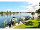 View from a condo of the boat dock and boat lifts with lush grass and palm trees at 9495 Blind Pass Rd # 206, St Pete Beach, FL 33706