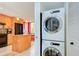 Efficient laundry area featuring a stacked washer and dryer unit, conveniently located near the kitchen with good storage space at 9495 Blind Pass Rd # 206, St Pete Beach, FL 33706