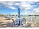 Outdoor deck with tables and chairs offering picturesque waterfront views under a sunny sky at 9495 Blind Pass Rd # 206, St Pete Beach, FL 33706