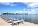 Lounge chairs on pool deck with stunning waterfront views on a sunny day at 9495 Blind Pass Rd # 206, St Pete Beach, FL 33706