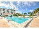 Inviting swimming pool with a brick patio and lounge chairs near lush tropical landscaping and the condo building at 9495 Blind Pass Rd # 206, St Pete Beach, FL 33706