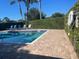 Community pool with lounge chairs and brick pavers at 3198 Claremont Pl # D, Palm Harbor, FL 34683