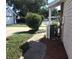 Side yard with mulch beds, walkway, and AC unit at 3198 Claremont Pl # D, Palm Harbor, FL 34683