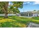 Large backyard with a screened patio, a tree swing, and well-maintained lawn at 13084 Drysdale St, Spring Hill, FL 34609