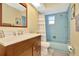 Bathroom with a blue tile bath, a bright vanity and light wall color at 13084 Drysdale St, Spring Hill, FL 34609