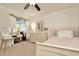 Light-filled bedroom featuring a white bed frame, dresser and light-colored carpet at 13084 Drysdale St, Spring Hill, FL 34609