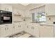 Traditional kitchen with white cabinets, neutral countertops, and modern appliances at 13084 Drysdale St, Spring Hill, FL 34609