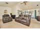 Comfortable living room with neutral carpet, recliner seating, and view to the backyard at 13084 Drysdale St, Spring Hill, FL 34609