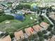 Aerial view showcasing community, golf course, and lake at 1361 Emerald Dunes, Sun City Center, FL 33573