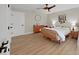 Cozy bedroom with a rattan bed frame, light wood floors, and ceiling fan at 9841 San Sebastian Way, Port Richey, FL 34668