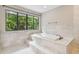 Elegant bathroom with soaking tub and marble tile at 17307 Linda Vista Cir, Lutz, FL 33548