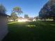 Large backyard with green grass, trees and single-story home at 6002 Christy Ln, Riverview, FL 33578