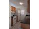 Kitchen featuring wood cabinets, white appliances, and an outside door at 6002 Christy Ln, Riverview, FL 33578