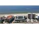 A high-angle view of beachfront condos, blue ocean, and a white sandy beach on a sunny day at 19440 Gulf Blvd # 201, Indian Shores, FL 33785