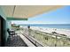 Balcony overlooking the beach and the ocean with pool and palm trees at 19440 Gulf Blvd # 201, Indian Shores, FL 33785