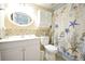 Well-lit bathroom with beach-themed decor, vanity, toilet, and tiled shower at 19440 Gulf Blvd # 201, Indian Shores, FL 33785