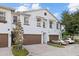 Three-unit townhouse building with brown garage doors and cars parked at 11516 Bellamar St, Temple Terrace, FL 33637