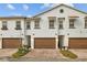 Three-unit townhouse building, brown garages, brick driveway, and landscaping at 11516 Bellamar St, Temple Terrace, FL 33637