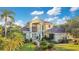 Two-story house with a grand entrance, lush landscaping, and a large yard at 1935 Lago Vista Blvd, Palm Harbor, FL 34685