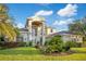 Impressive two-story home featuring a grand entryway and manicured landscaping at 1935 Lago Vista Blvd, Palm Harbor, FL 34685