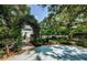 Inviting entryway with brick path and arbor covered in lush greenery at 5455 Lake Le Clare Rd, Lutz, FL 33558