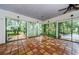 Sunroom featuring terracotta tile floors and backyard access at 5455 Lake Le Clare Rd, Lutz, FL 33558