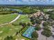 Aerial view of golf course, lake, tennis courts and clubhouse at 7656 Portstewart Dr, Lakewood Ranch, FL 34202