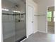 Bathroom featuring a glass-enclosed shower with tiled walls and adjacent doorway to bedroom at 7656 Portstewart Dr, Lakewood Ranch, FL 34202