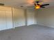 Bedroom with neutral carpet and ceiling fan, featuring two closets for ample storage at 7656 Portstewart Dr, Lakewood Ranch, FL 34202