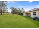 Large backyard with a sloping lawn and mature trees at 4638 Southern Valley Loop, Brooksville, FL 34601