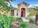 House exterior with a red door and lush landscaping at 10718 Standing Stone Dr, Wimauma, FL 33598