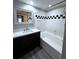 Bathroom with a bathtub, vanity, and checkerboard tile at 2410 W Azeele St # 212, Tampa, FL 33609