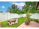 Backyard with grassy area, potted plants, and a wood slab structure at 6906 N Clark Ave, Tampa, FL 33614